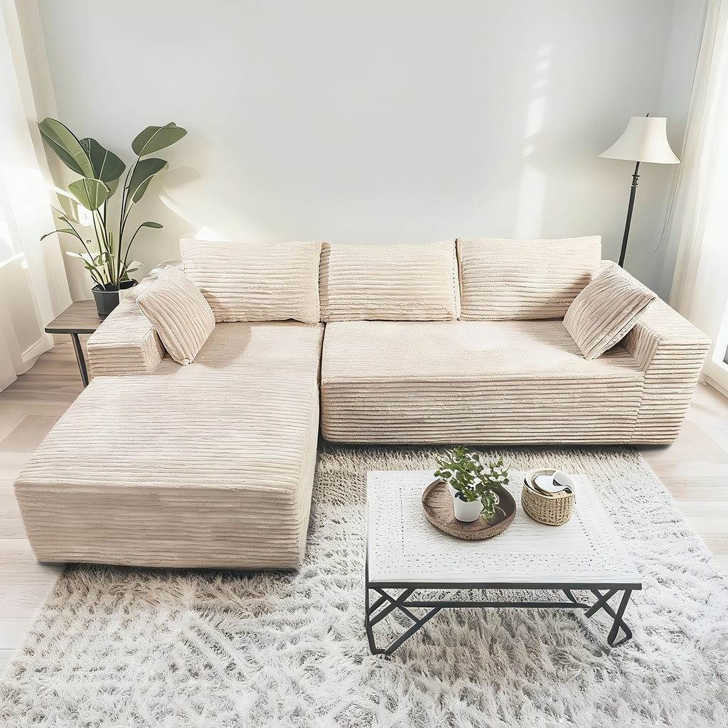 Elegant Contemporary Living Room Setup: Soft Ribbed Fabric Corner Sofa, Light-Filled Interior, And Curated Tabletop Greenery